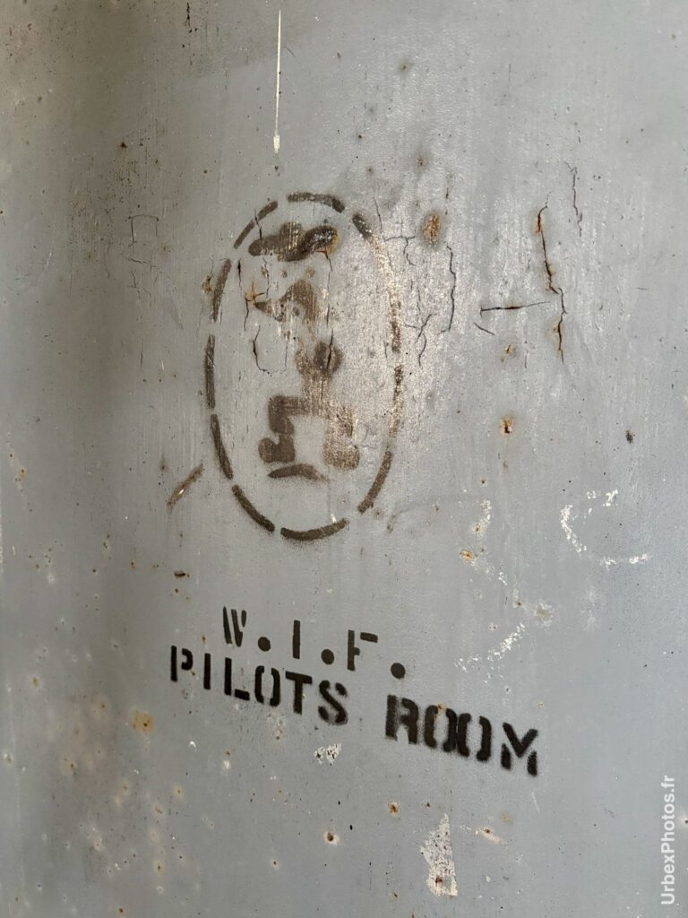Mention salle des pilotes peinte au pochoir sur une porte d'une ancienne base de l'OTAN