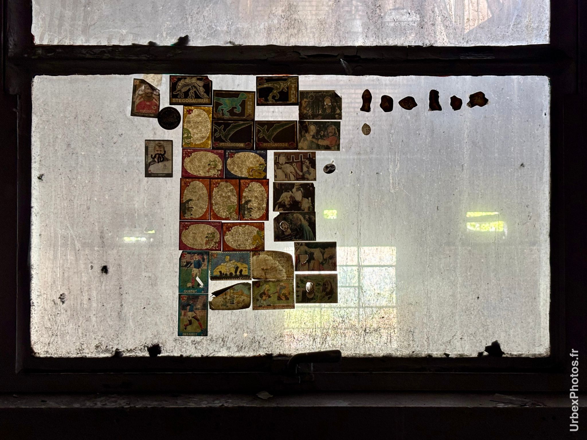 Des vignettes Panini anciennes collées sur une vitre sale
