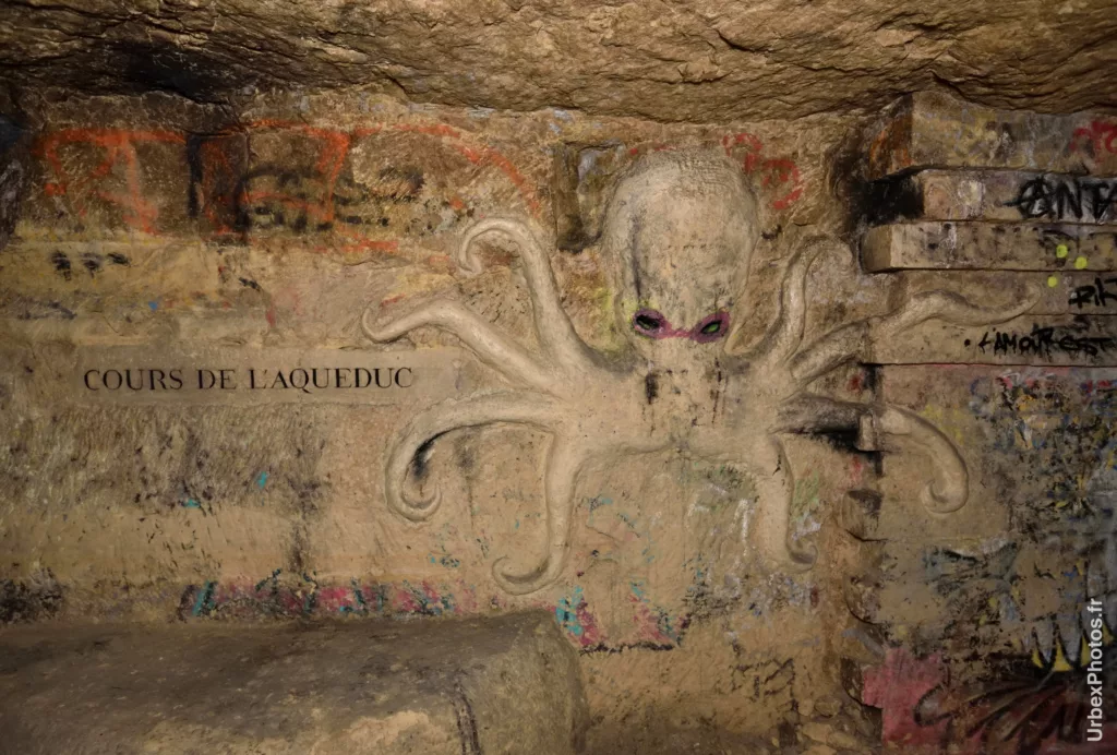 Sculpture d'une pieuvre à côté de l'inscription Cours de l'aqueduc