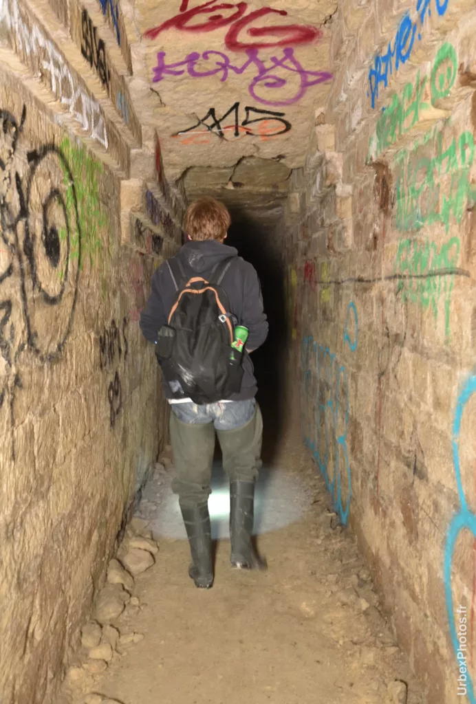 Photo urbex d'un cataphile de dos dans une galerie des catacombes interdites de Paris